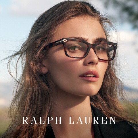 Das Bild zeigt das Gesicht einer jungen Frau mit Brille. Sie ist im Freien.
