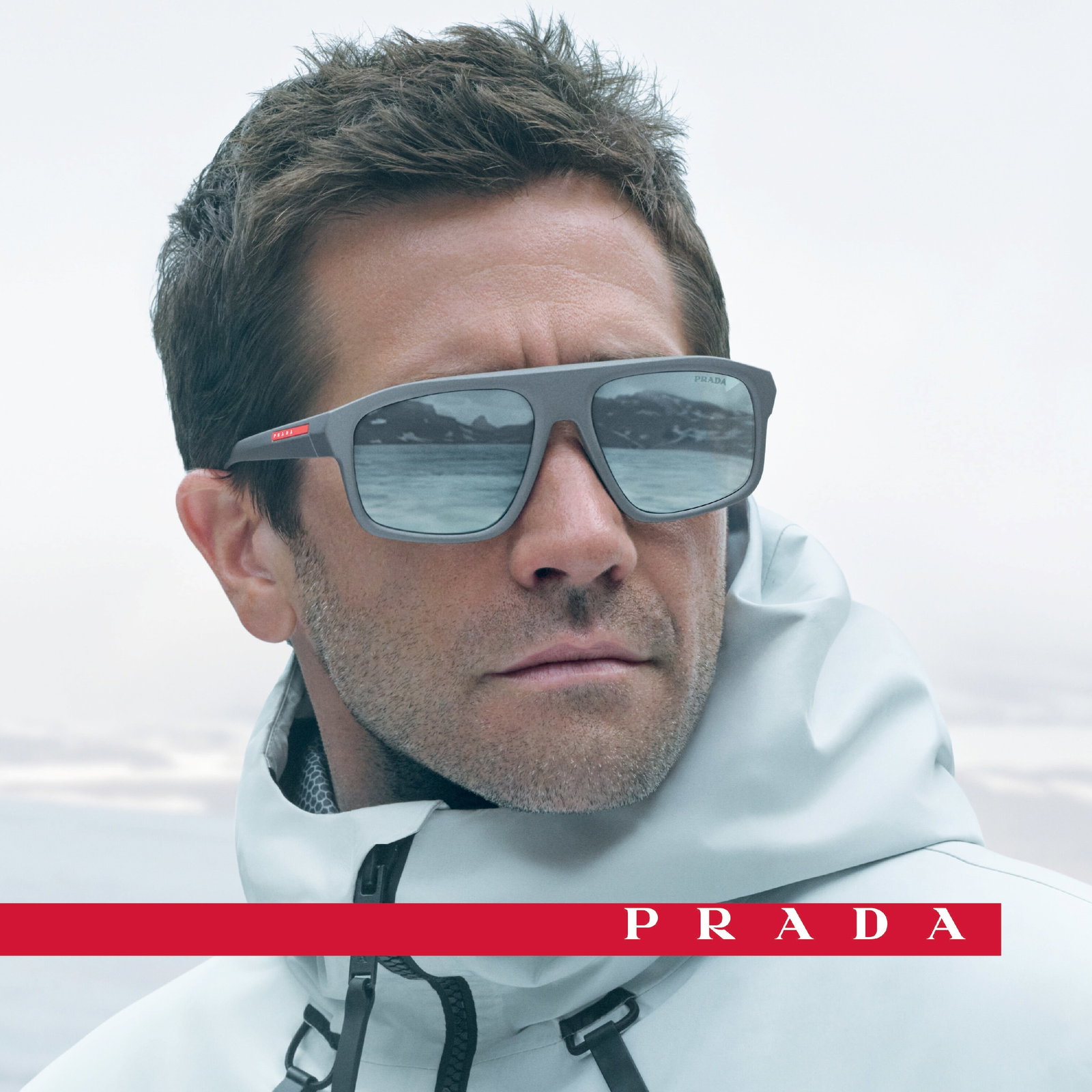 Das Bild zeigt Jake Gyllenhaal mit Sonnenbrille und weißer Skijacke.