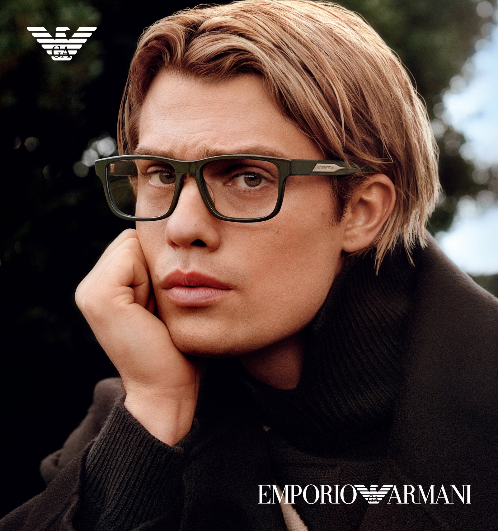 Das Bild zeigt einen jungen,blonden Mann mit Brille in nachdenklicher Pose.
