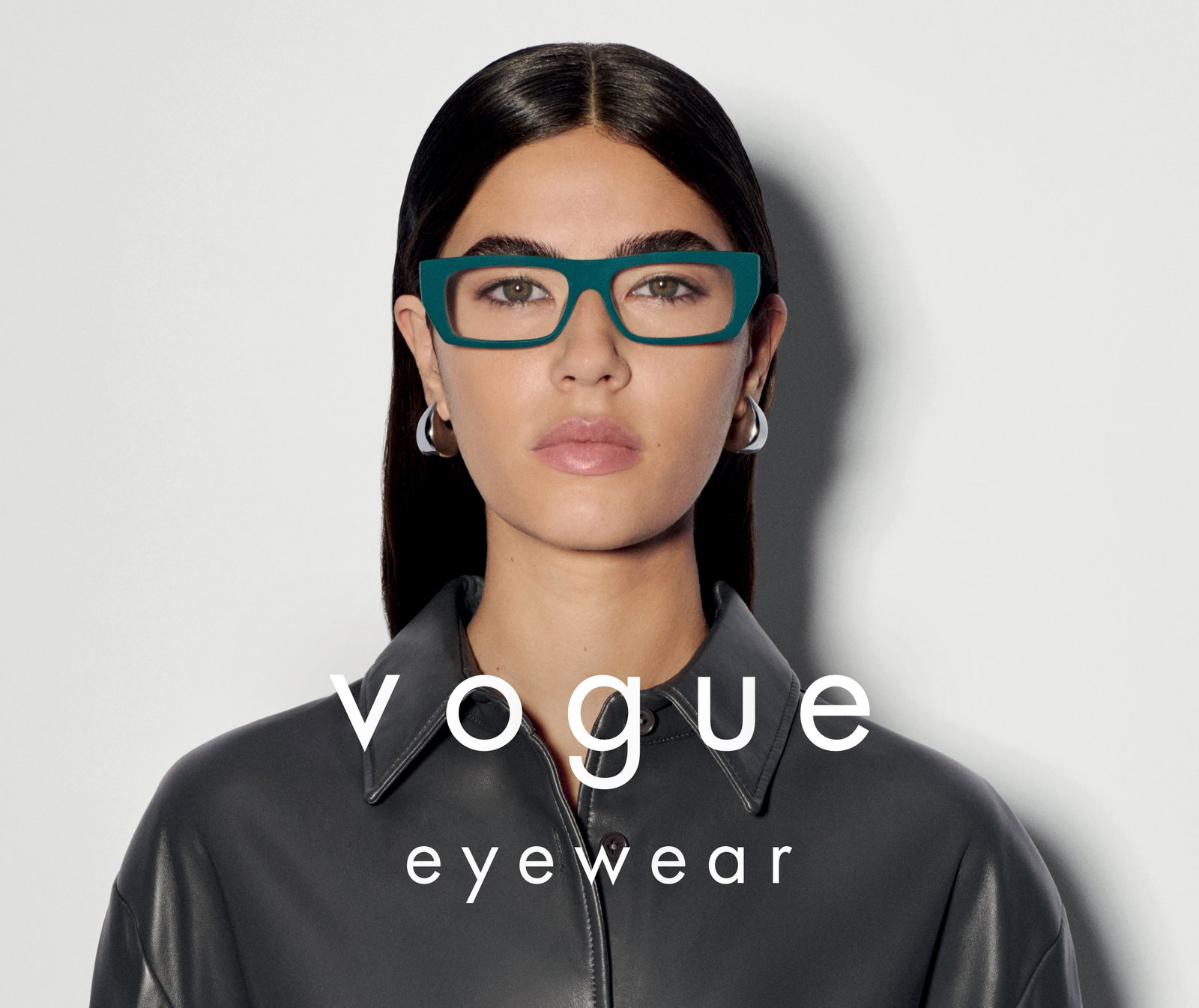 Das Bild zeigt eine junge Frau mit einer grünen Brille. Davor steht das Vogue Logo.