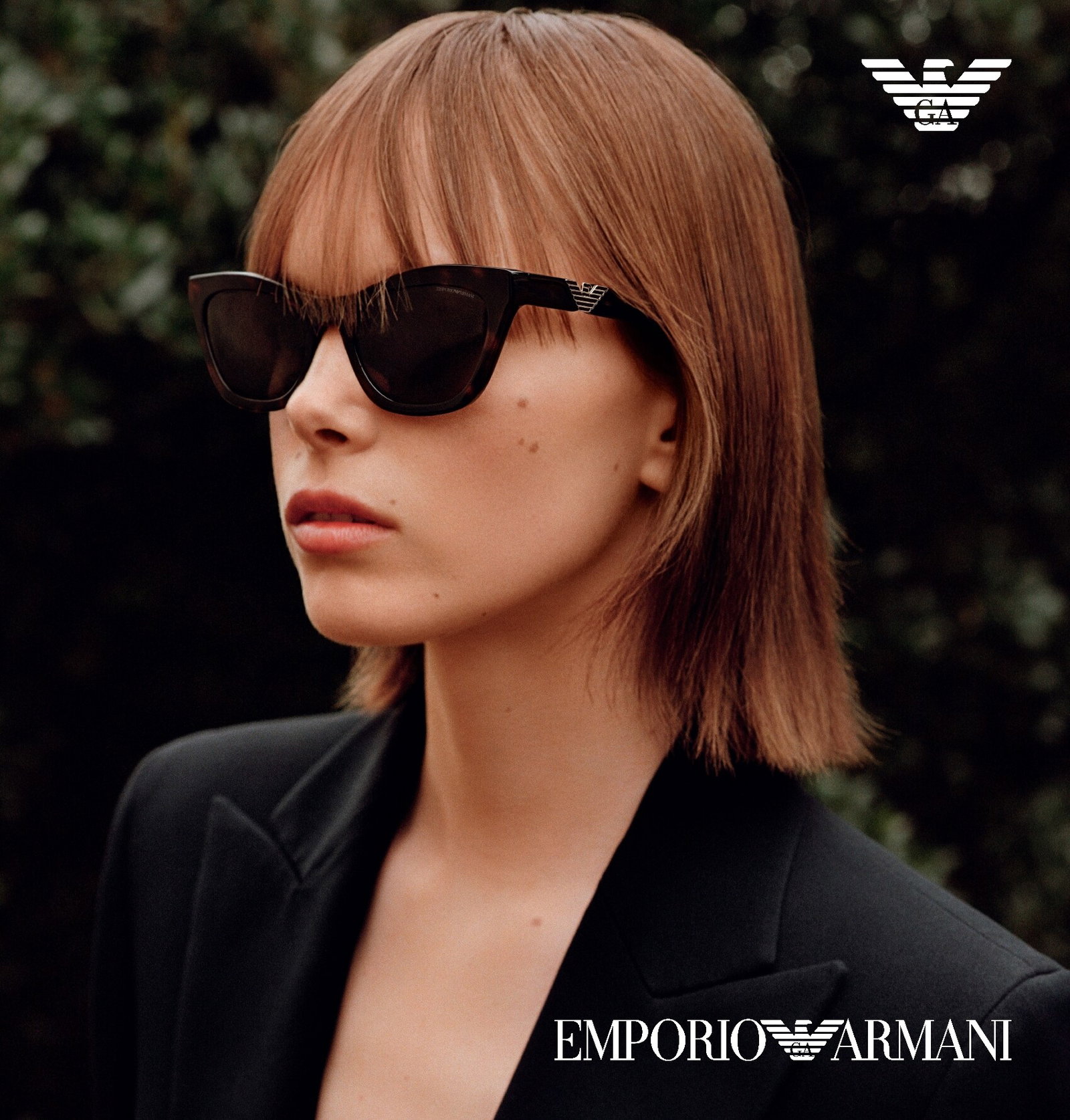 Das Bild zeigt eine junge Frau mit schwarzer Sonnenbrille und schwarzem Blazer.