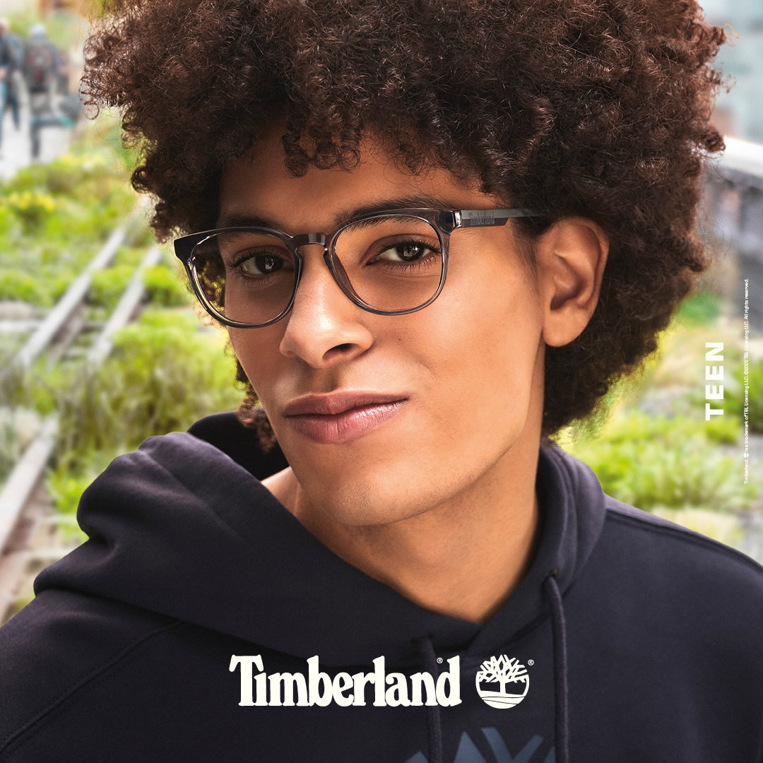 Das Bild zeigt das Gesicht eines jungen Mannes mit Brille. Davor ist das Timberland Logo zu sehen.